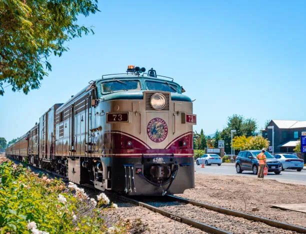 Napa Wine Train passing through scenic Napa Valley vineyards on a sunny day